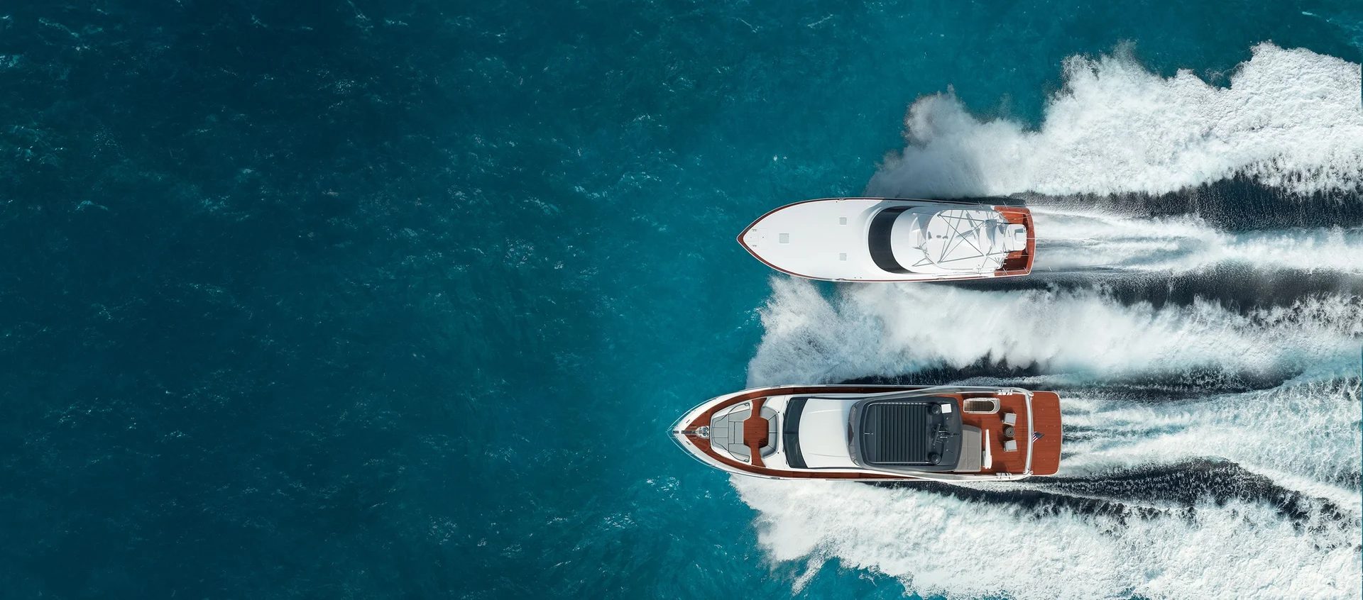 Aerial view of two large yachts cruising through deep blue water