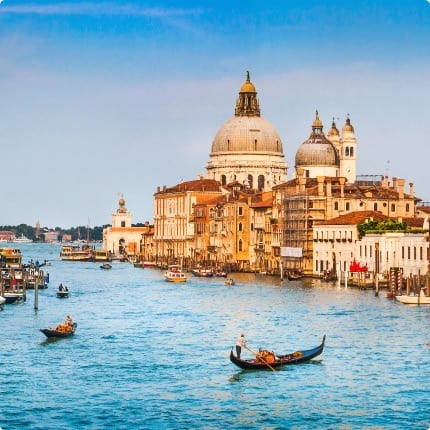 Panoramic view of a picturesque Italian harbor town with pastel buildings reflected in calm azure waters