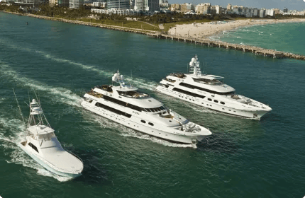 The Risotti fleet of motor yachts and a sportfish escort cruising past Fisher Island in Miami.